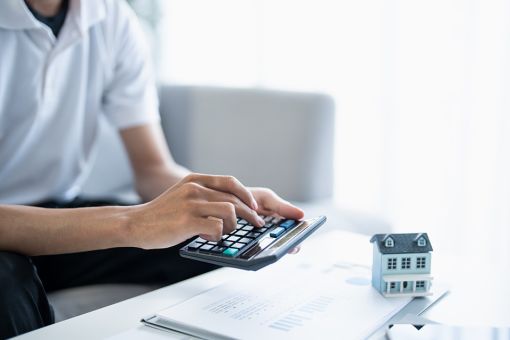 © Charlie's - Adobe Stock.com Foto: Mann tippt auf Taschenrechner