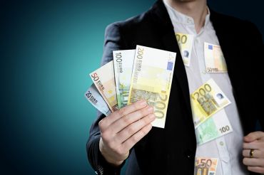 © lassedesignen - stock.adobe.com Foto: Mann mit Geldscheinen